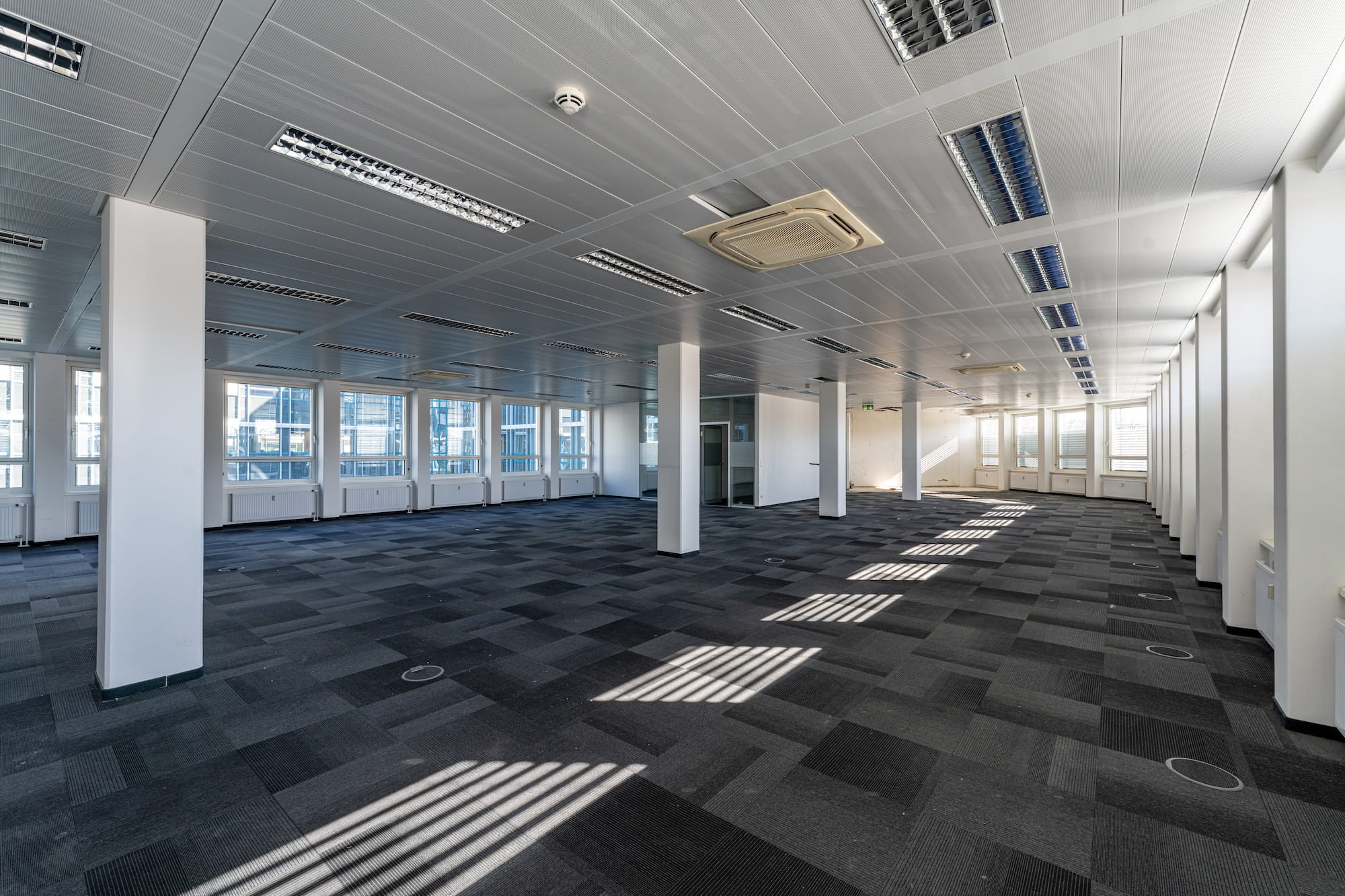 Großraumbüro im Bestand mit Rasterdecke und konventioneller Beleuchtung